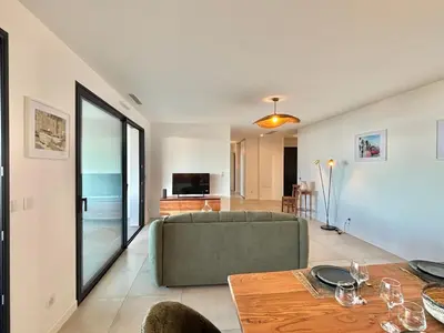 a living room with a couch and a table at Appartement vue mer Royal Palm Porticcio in Porticcio