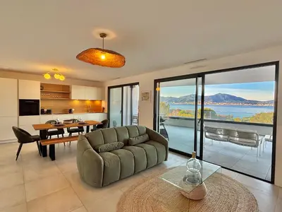 a living room with a couch and a table at Appartement vue mer Royal Palm Porticcio in Porticcio