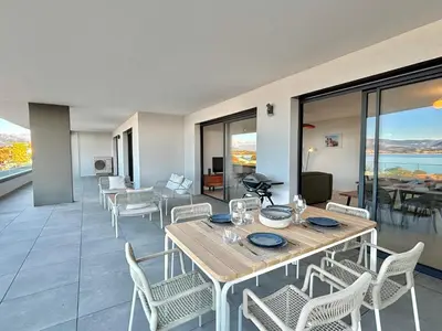a dining room with a table and chairs at Appartement vue mer Royal Palm Porticcio in Porticcio