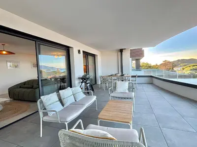 a living room with a couch and chairs and a table at Appartement vue mer Royal Palm Porticcio in Porticcio