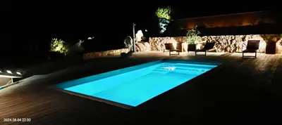 a swimming pool in a yard at night at A l'Orée du Maquis Villa 6 personnes in Bonifacio