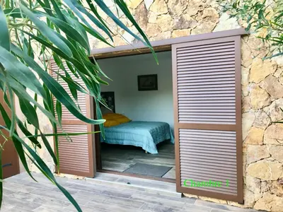 a bedroom with a bed inside of a building at A l'Orée du Maquis Villa 6 personnes in Bonifacio