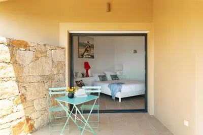 a bedroom with a bed and a table and a room with a bed at AZUR E CASTELLU - CORSE SUD - Pied à terre IDEAL in Calcatoggio