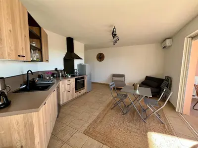 a kitchen with a sink and a table with chairs at Très beau T3 5 min plage à pieds in Albitreccia