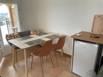 a dining table and chairs in a room with a television at Résidence U Sognu in Porto-Vecchio