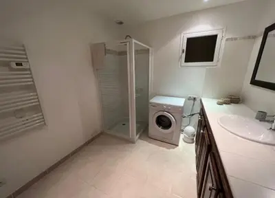 a bathroom with a washing machine and a sink at Résidence U Sognu in Porto-Vecchio