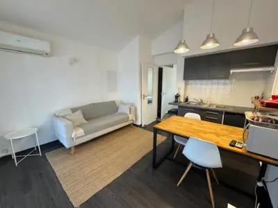 a kitchen and living room with a couch and a table at Résidence U Sognu in Porto-Vecchio