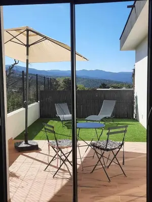 a patio with a table and chairs and an umbrella at Studio neuf porticcio in Porticcio