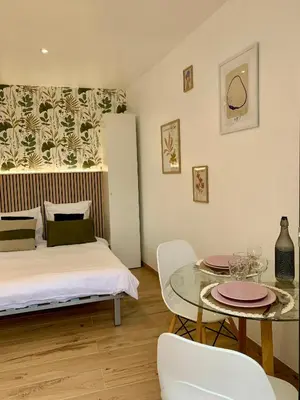 a bedroom with a bed and a table with chairs at Studio neuf porticcio in Porticcio