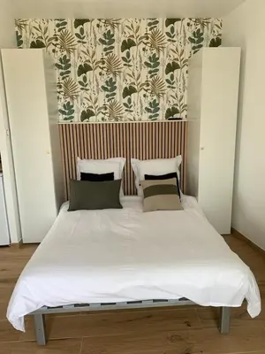 a bed with white sheets and pillows in a bedroom at Studio neuf porticcio in Porticcio