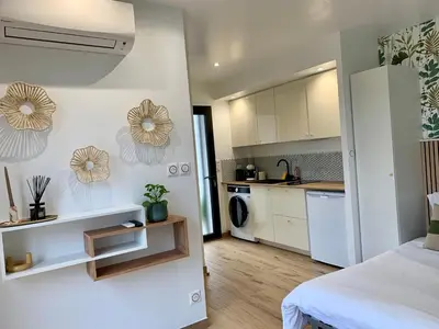 a room with a white kitchen and a bed at Studio neuf porticcio in Porticcio