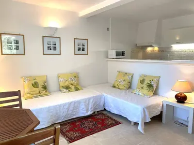 two beds in a room with a table and a kitchen at Appartement vue mer avec accès privé à la plage in Lecci