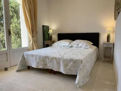 a bedroom with a bed with a white comforter and a window at Appartement vue mer avec accès privé à la plage in Lecci