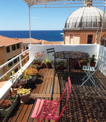 a balcony with a table and chairs and plants at T4 Terrasses Vieille ville, Ajaccio in Ajaccio