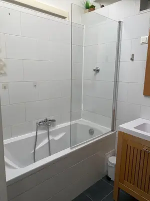 a white bathroom with a tub and a sink at T4 Terrasses Vieille ville, Ajaccio in Ajaccio