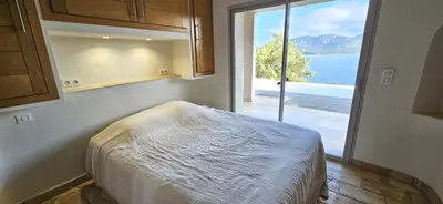 a bedroom with a large window with a view of the water at Marina-piscine privée-wifi-Accès Sporting Club Marina di Fiori in Porto-Vecchio