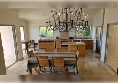 a dining room and kitchen with a chandelier at Marina-piscine privée-wifi-Accès Sporting Club Marina di Fiori in Porto-Vecchio