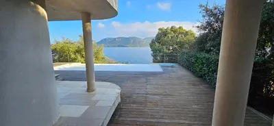 a porch with a view of a body of water at Marina-piscine privée-wifi-Accès Sporting Club Marina di Fiori in Porto-Vecchio