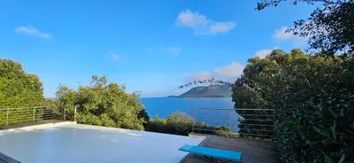 a blue bench sitting on top of a balcony overlooking the ocean at Marina-piscine privée-wifi-Accès Sporting Club Marina di Fiori in Porto-Vecchio