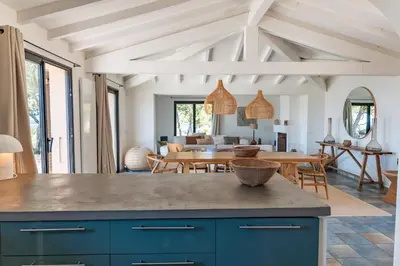 an open kitchen and dining room with blue cabinets at Casa Rocca Di Pianotolli in Pianottoli-Caldarello
