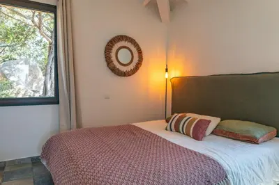 a bedroom with a bed with a mirror on the wall at Casa Rocca Di Pianotolli in Pianottoli-Caldarello