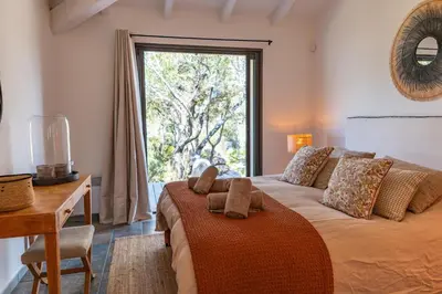 a bedroom with a bed with a desk and a window at Casa Rocca Di Pianotolli in Pianottoli-Caldarello