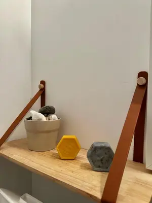 a wooden shelf with rocks and a yellow box on it at Studio les pieds dans l'eau in Santa-Lucia-di-Moriani