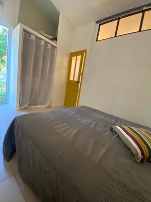 a bedroom with a large bed with a window at Mini villa avec jardin in Borgo