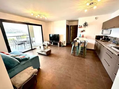 a kitchen and living room with a couch and a table at Superbe T3 front de mer au centre de Propriano in Propriano