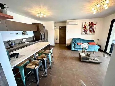 a kitchen and a living room with a blue couch at Superbe T3 front de mer au centre de Propriano in Propriano