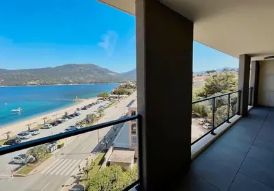 a balcony with a view of a beach and the ocean at Superbe T3 front de mer au centre de Propriano in Propriano