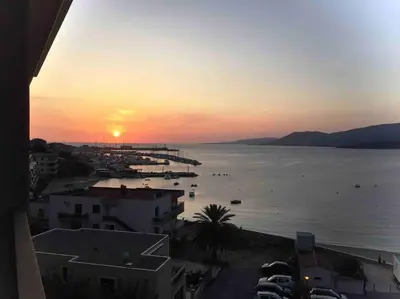 a sunset over a body of water with boats at Superbe T3 front de mer au centre de Propriano in Propriano