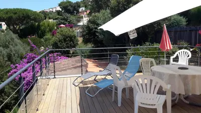 a deck with a table and chairs and an umbrella at Vue Panoramique in Porticcio