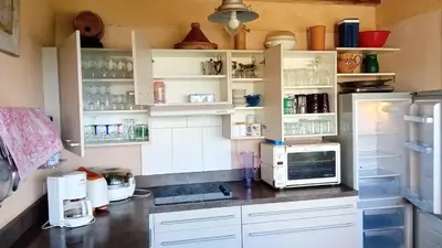 a kitchen with white cabinets and a refrigerator at Vue Panoramique in Porticcio
