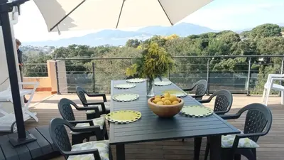 a barbecue on a wooden deck with a fence at Vue Panoramique in Porticcio
