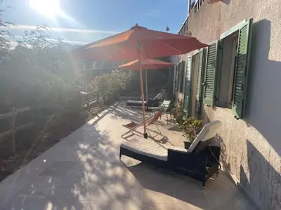 a patio with an umbrella and chairs and a table at Casa Mimosa in Piana