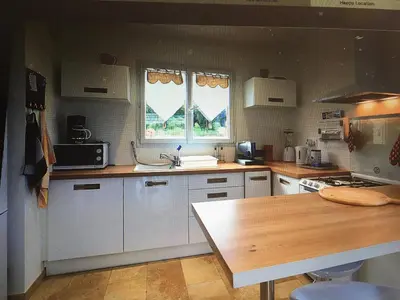 a kitchen with white cabinets and a wooden counter top at La Carpe Diem in Cervione