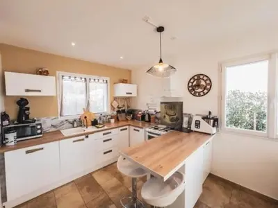a kitchen with white cabinets and a wooden counter top at La Carpe Diem in Cervione