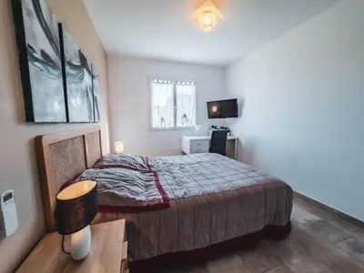 a bedroom with a bed and a desk and a television at La Carpe Diem in Cervione