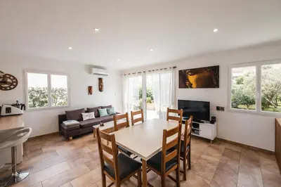 a kitchen and living room with a table and chairs at La Carpe Diem in Cervione