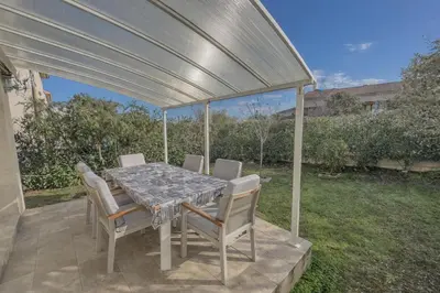 a dining table and chairs under a pergola at La Carpe Diem in Cervione
