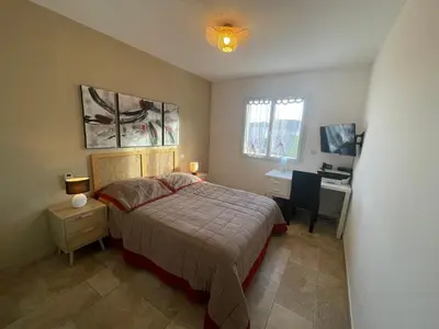 a bedroom with a bed and a desk with a computer at La Carpe Diem in Cervione