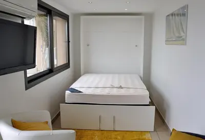 a bedroom with a bed on top of a cabinet at So Leil So Fun à Porticcio - 45m2 - Grand lit 180 - Plage à pied - Wifi fibre - Terrasse in Porticcio