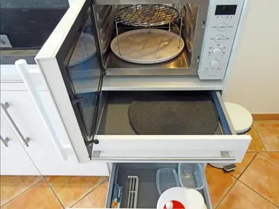 a microwave oven with its door open in a kitchen at So Leil So Fun à Porticcio - 45m2 - Grand lit 180 - Plage à pied - Wifi fibre - Terrasse in Porticcio