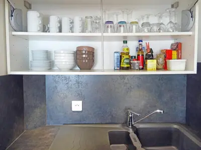 a kitchen with a sink and a shelf with dishes at So Leil So Fun à Porticcio - 45m2 - Grand lit 180 - Plage à pied - Wifi fibre - Terrasse in Porticcio