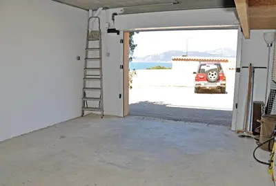 a garage door open to a garage with a ladder at So Leil So Fun à Porticcio - 45m2 - Grand lit 180 - Plage à pied - Wifi fibre - Terrasse in Porticcio