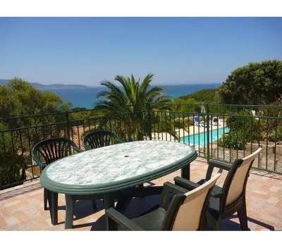 a table and chairs on a balcony with a pool at Residence les Lavandes in Olmeto
