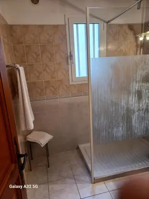 a bathroom with a shower with a glass door at Residence les Lavandes in Olmeto