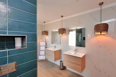 a bathroom with two sinks and a mirror at Domaine Pozzo di Mastri hôtel & spa in Figari