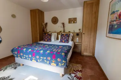 a bedroom with a bed with a colorful comforter at Domaine Pozzo di Mastri hôtel & spa in Figari